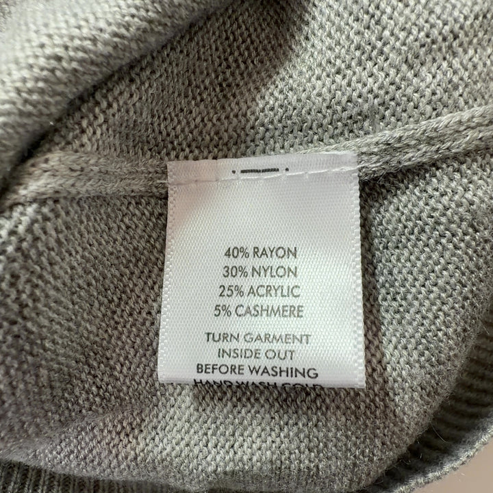 Tag view of beige knit pullover sweater showing clean silhouette and relaxed fit