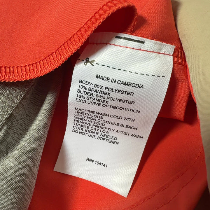 Red athletic shorts with gray compression liners, back view displaying relaxed fit and mid-thigh length