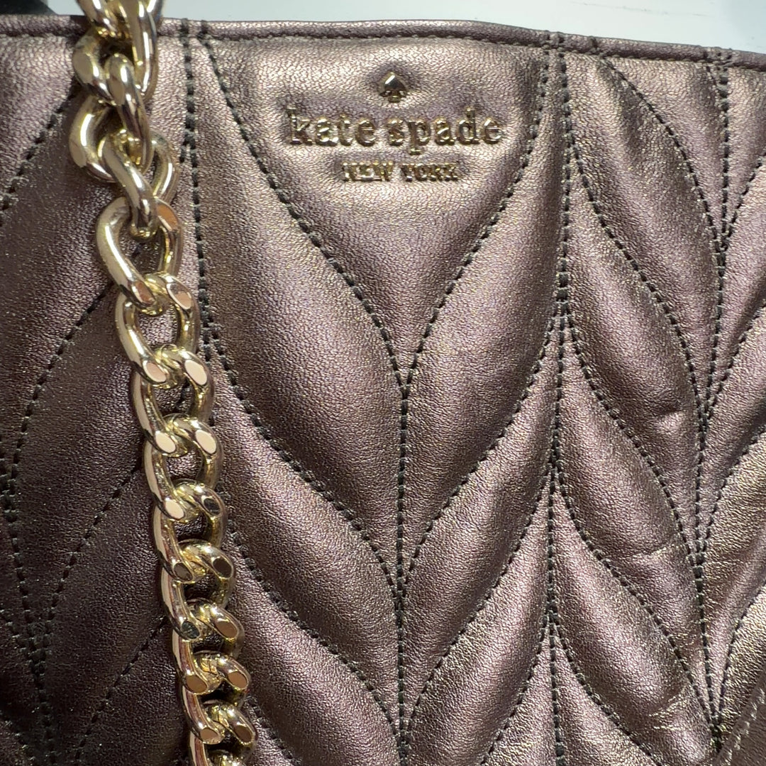 Rose gold Kate Spade quilted leather shoulder bag worn on shoulder, back view showing chain strap detail