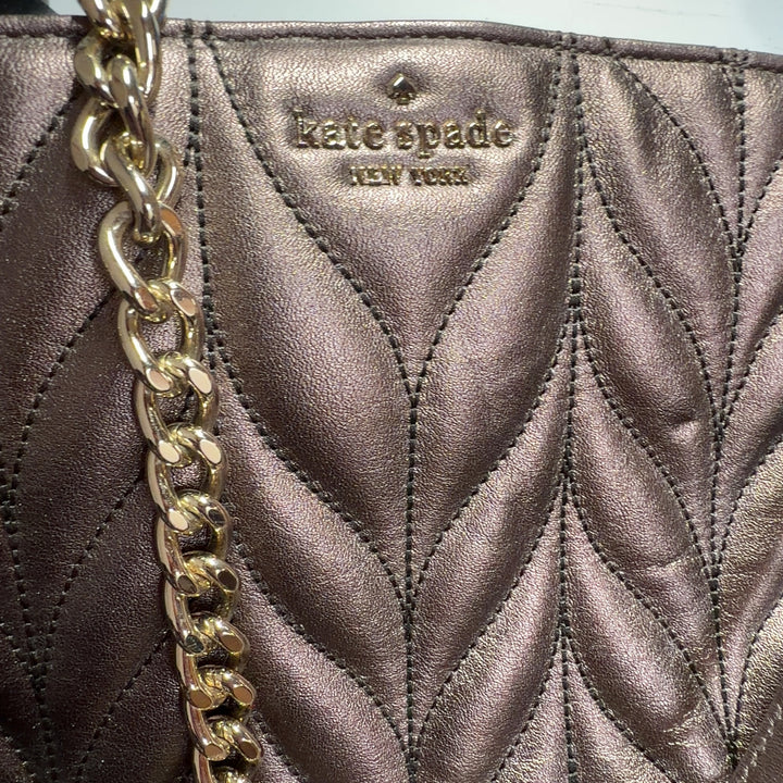 Rose gold Kate Spade quilted leather shoulder bag worn on shoulder, back view showing chain strap detail
