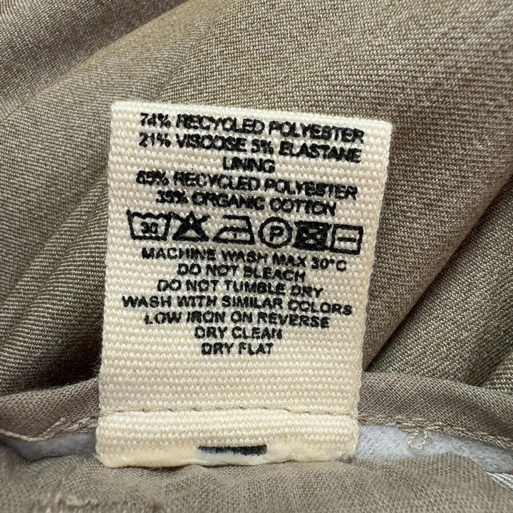 Tag view of beige paperbag waist trousers showing structured waistband and flattering silhouette