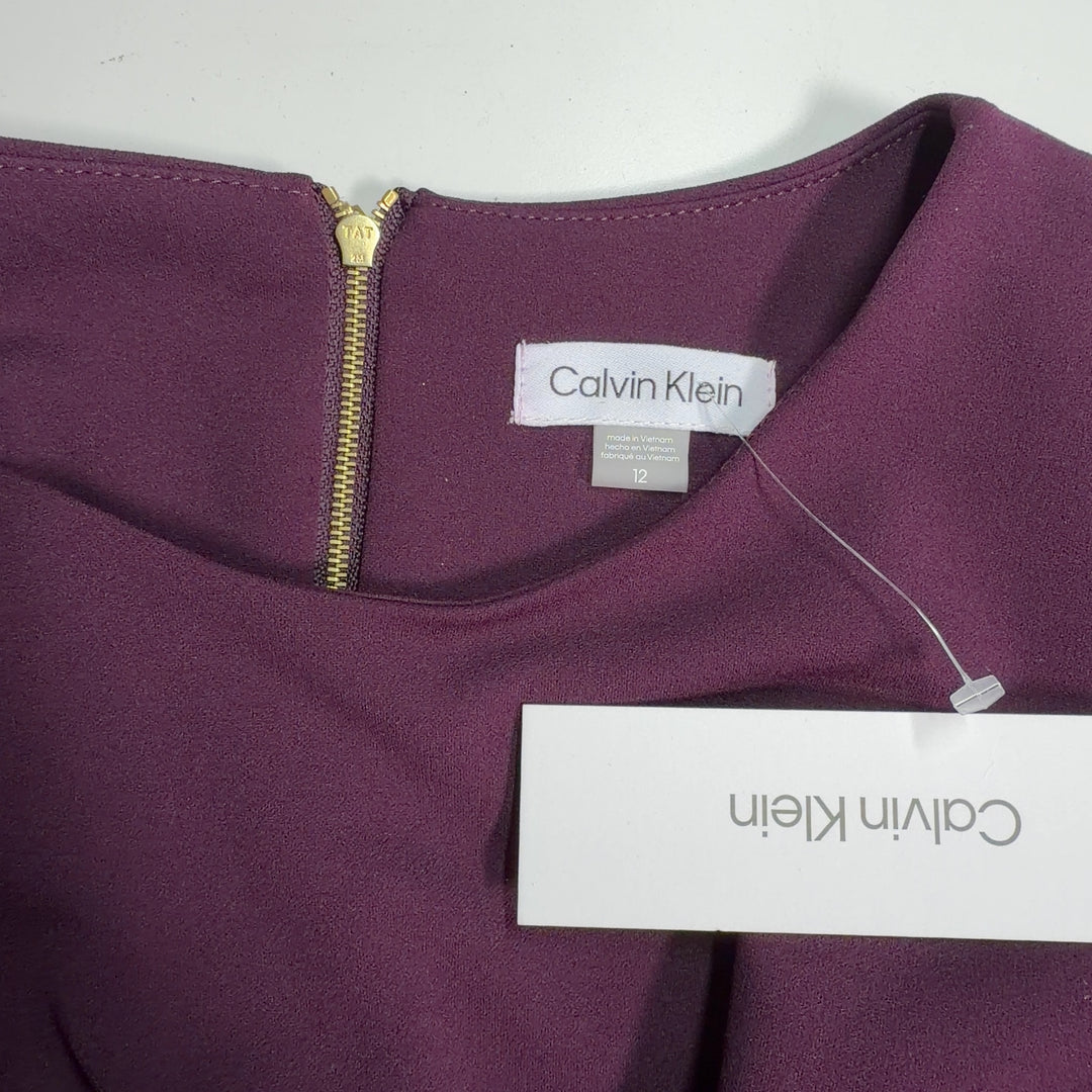 Burgundy cape sleeve A-line dress by Calvin Klein, back view displaying flowing cape sleeves and A-line silhouette
