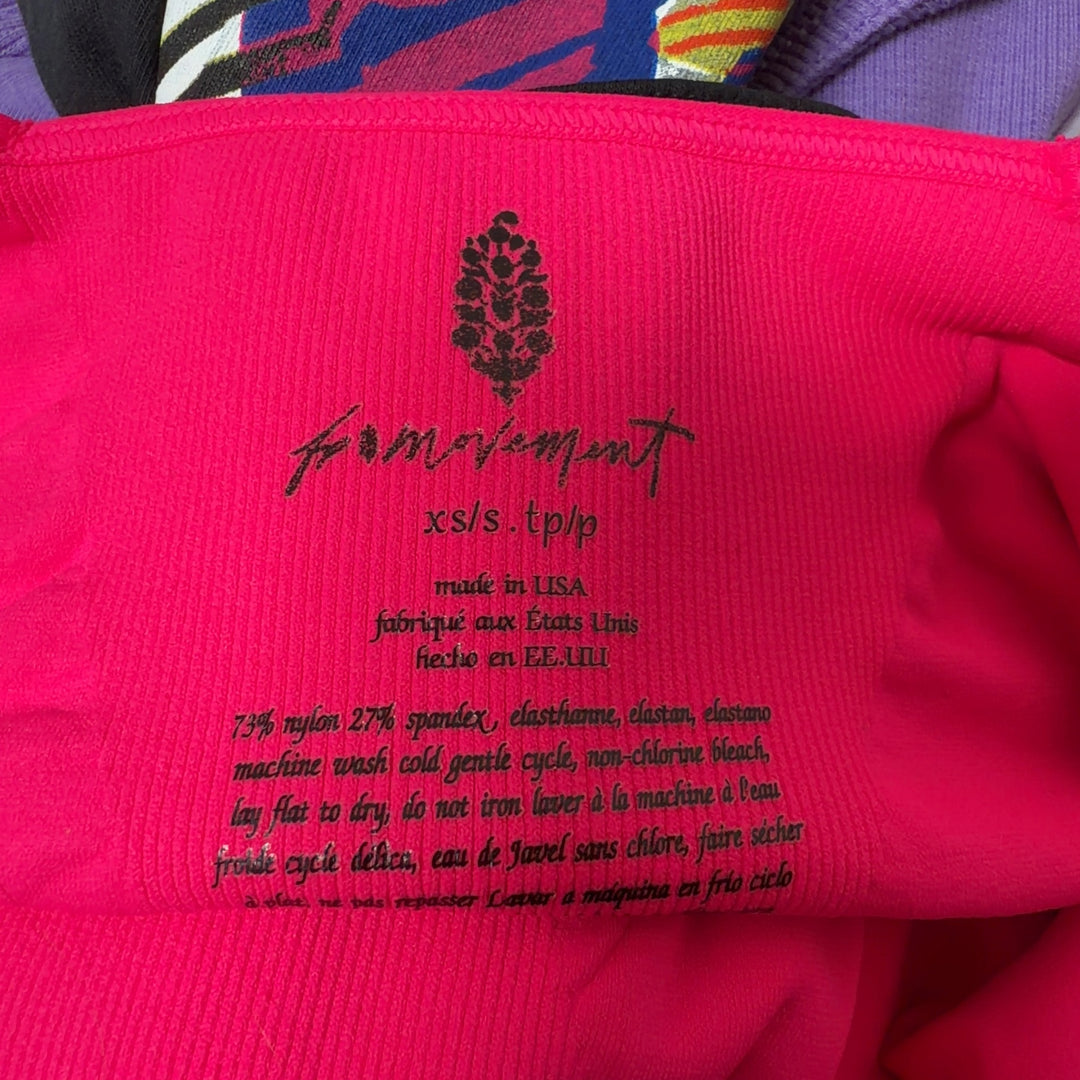 Tag view of pink ribbed sports bra showing supportive racerback design and fit on black leggings