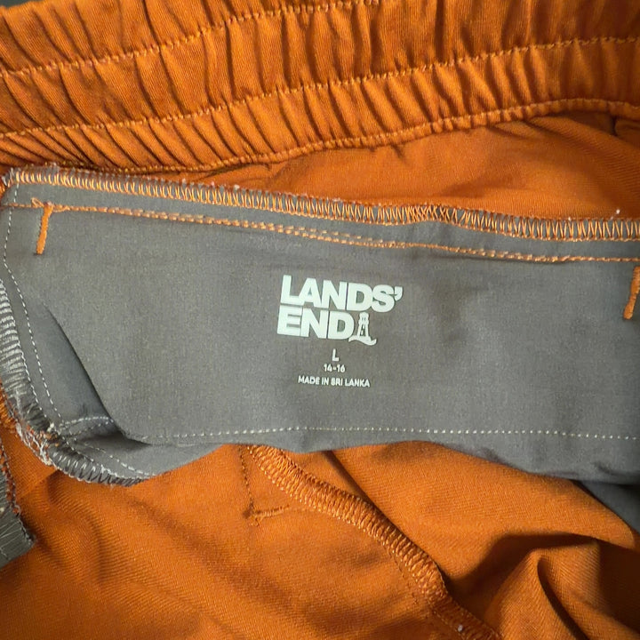 Tag view of orange cropped polyester pants by Lands' End showing fit and length, paired with black crop top