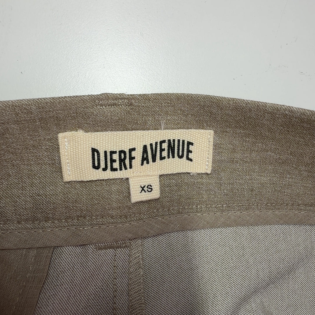 Tag view of beige paperbag waist trousers showing structured waistband and flattering silhouette