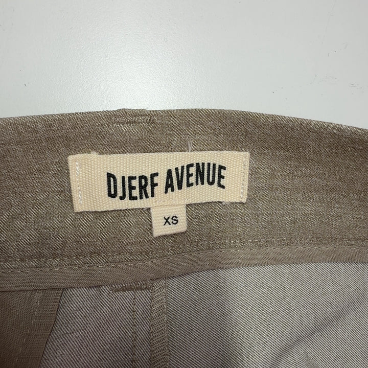 Tag view of beige paperbag waist trousers showing structured waistband and flattering silhouette