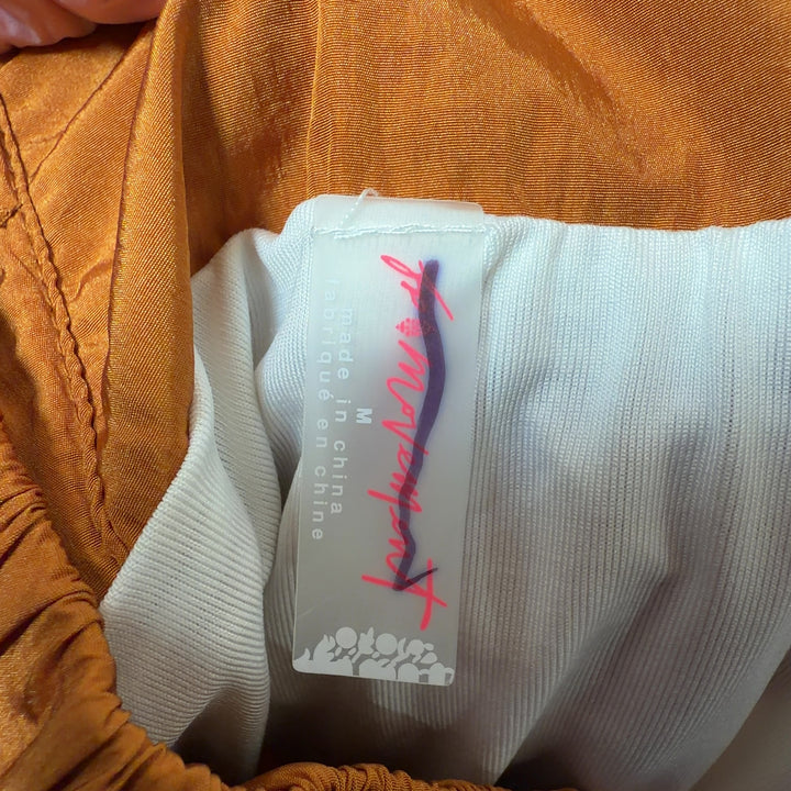 Tag view of orange bubble shorts showing the voluminous bubble hem silhouette and relaxed fit