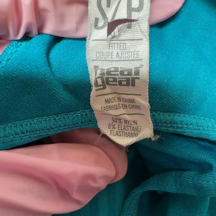 Woman wearing turquoise striped Under Armour racerback athletic tank, back view showing fitted silhouette