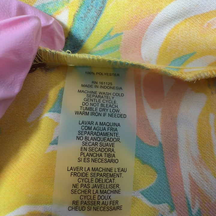 Tag view of yellow floral Sioni top showing pleated bell sleeves and relaxed fit silhouette