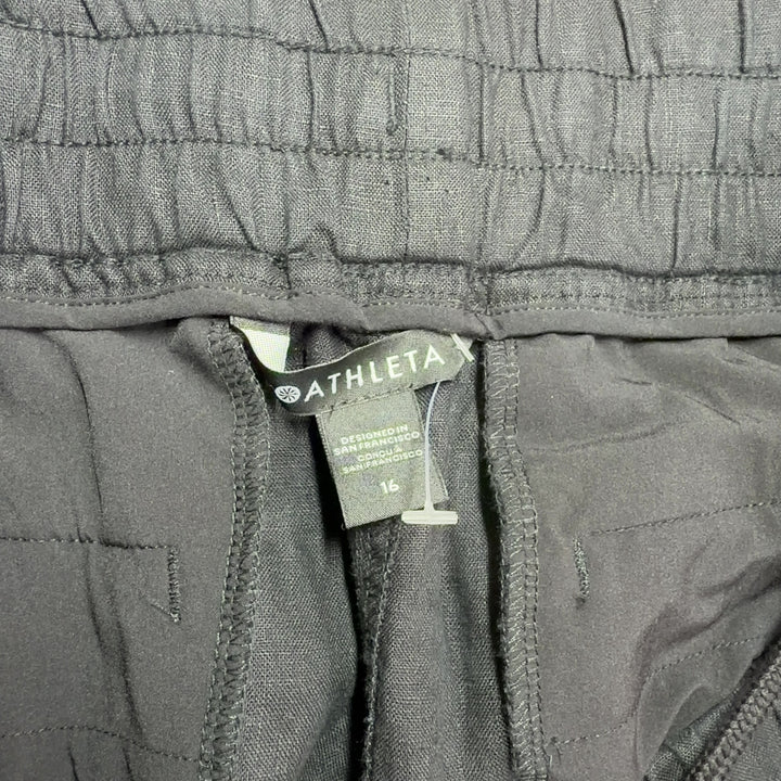Black drawstring athletic shorts with functional pockets, back view