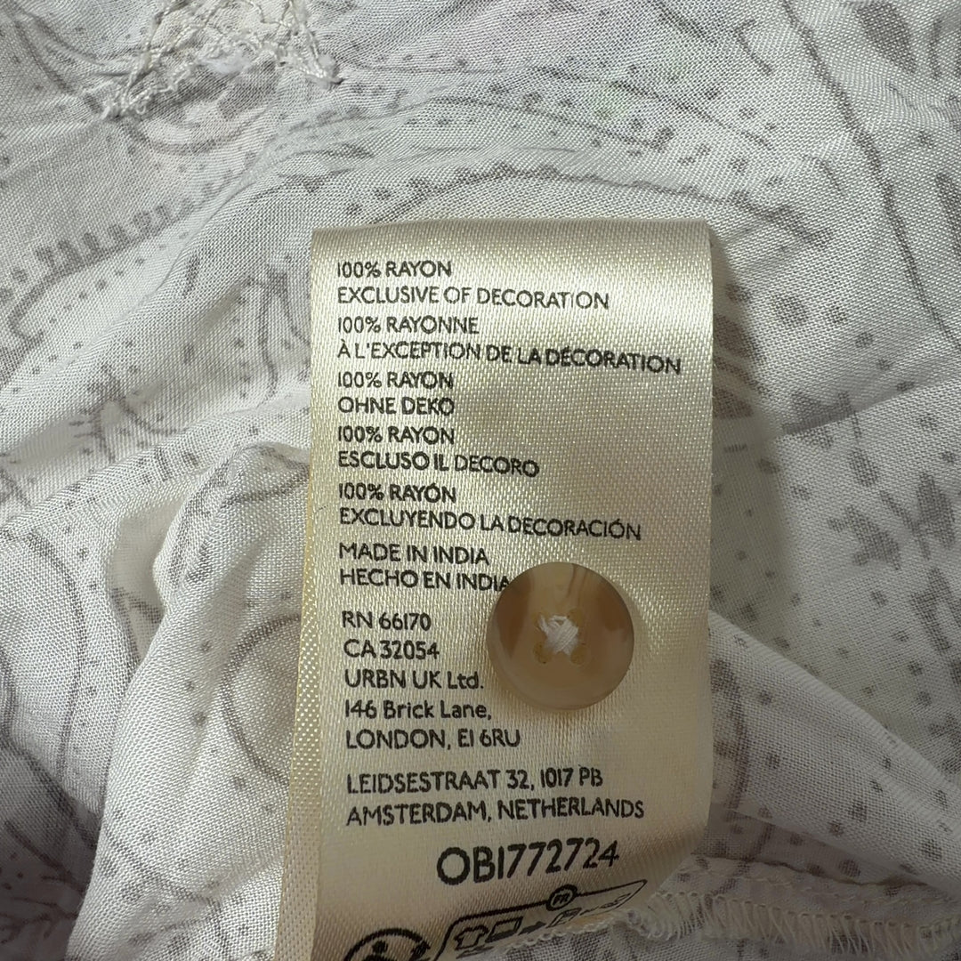 Tag view of cream Pilcro embroidered rayon shirt showing scattered whimsical motifs and button-up closure