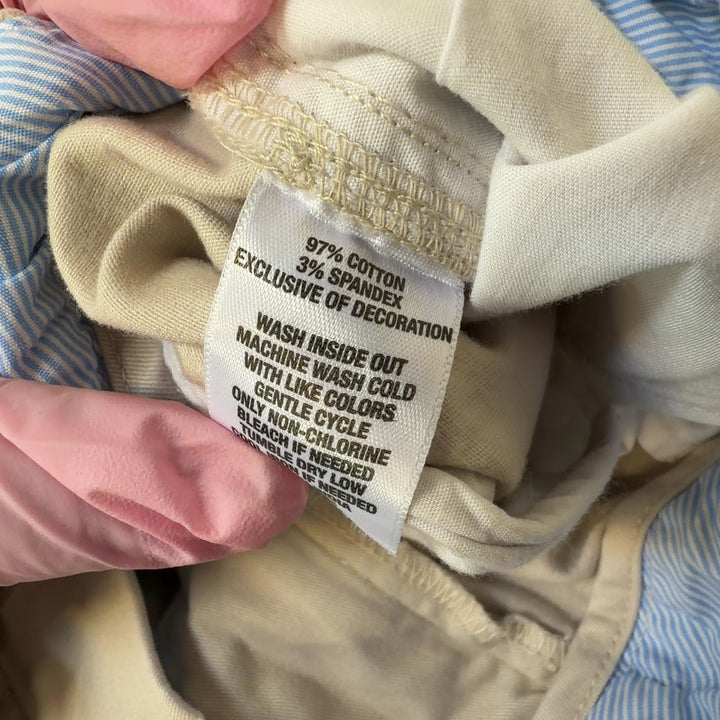 Tag view of cream tailored shorts showing flattering fit and classic silhouette