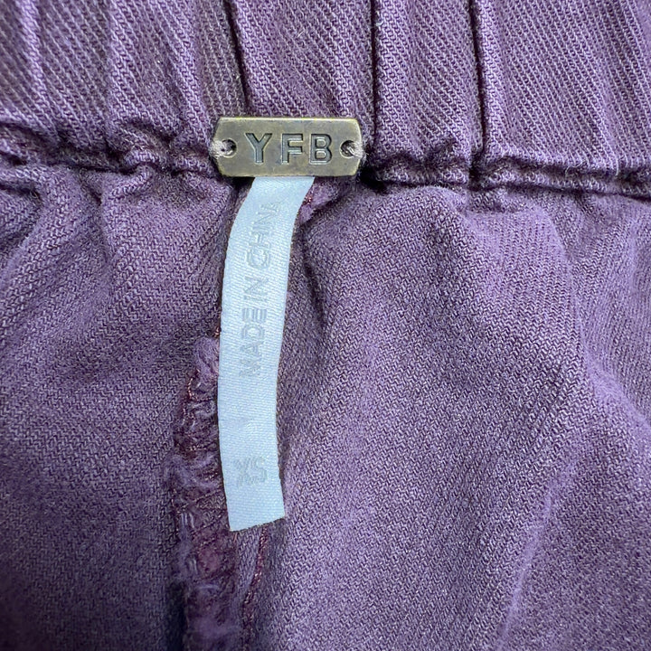 Tag view of burgundy wide-leg pants showing relaxed fit through hip and thigh, demonstrating the comfortable and stylish cut of Young Fabulous & Broke design