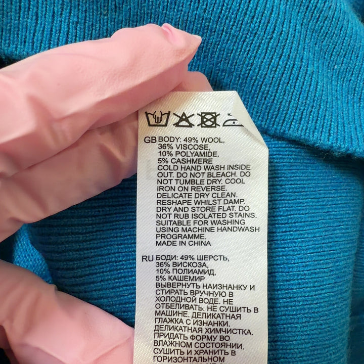Blue V-neck cashmere blend knit sweater with ruched sleeves, back view on model