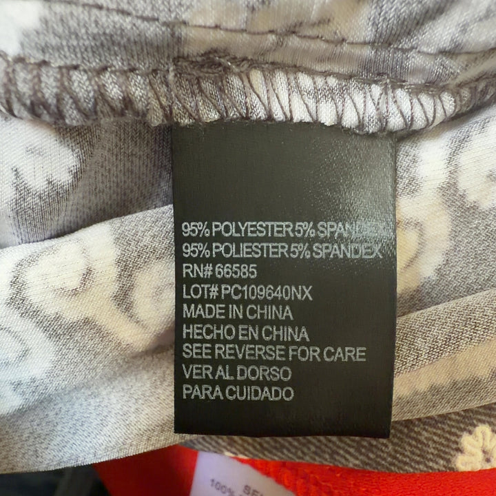 Tag view of taupe geometric print A-line dress showing full ornamental pattern and relaxed A-line silhouette