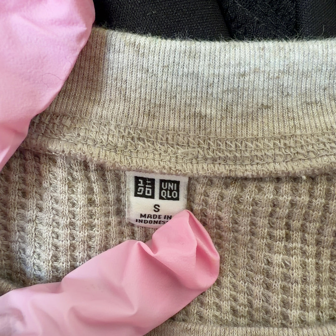 Beige ribbed cotton knit sweater back view showing relaxed fit and curved hem
