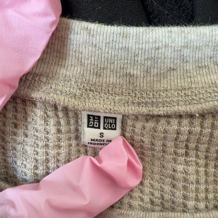 Beige ribbed cotton knit sweater back view showing relaxed fit and curved hem