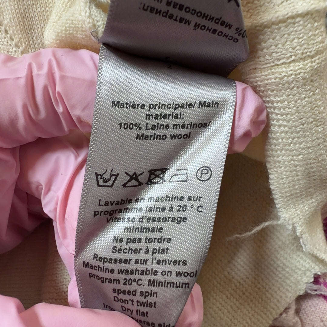 Tag view of cream merino wool sweater showing matching skull graphic design