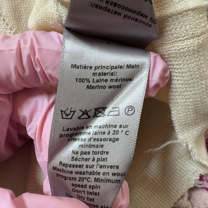 Tag view of cream merino wool sweater showing matching skull graphic design