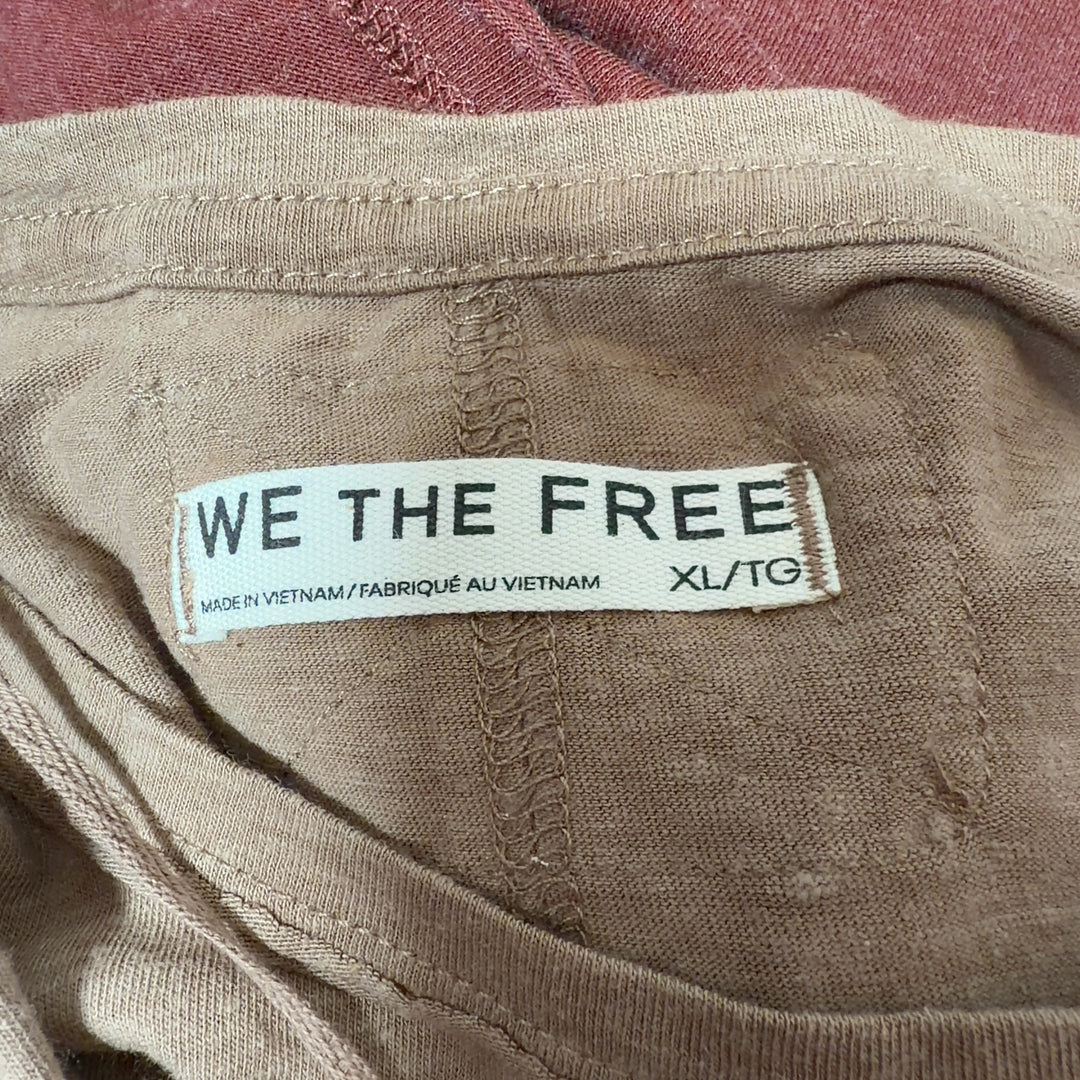 Woman wearing tan organic cotton crew neck t-shirt by WE THE FREE, back view with side profile