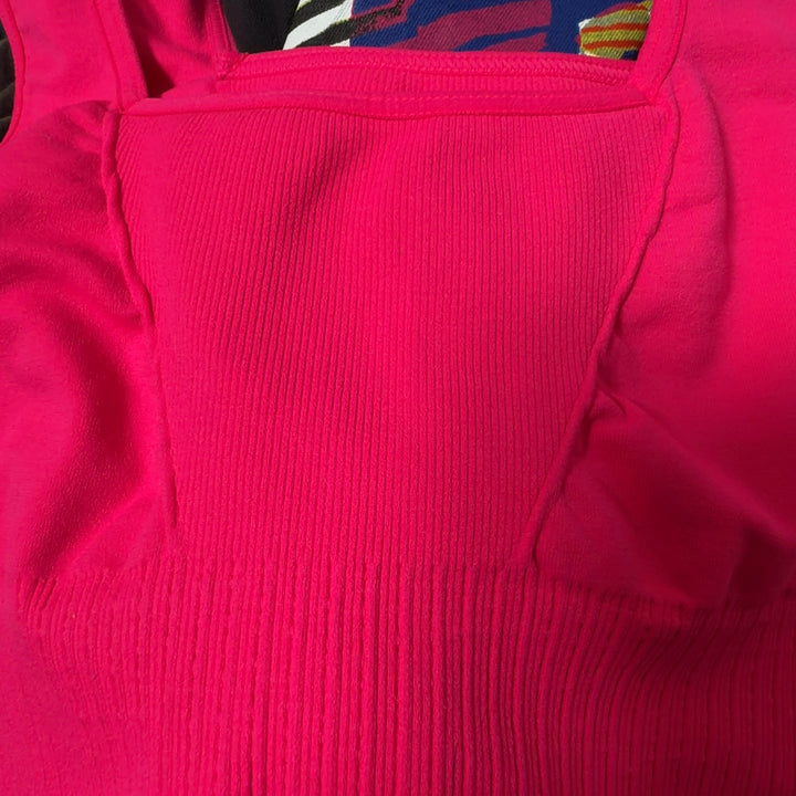 Tag view of pink ribbed sports bra showing supportive racerback design and fit on black leggings
