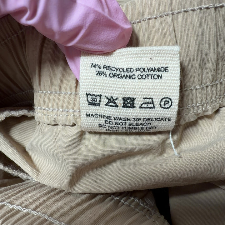 Beige cargo pants with drawstring waist and functional pockets, back view on model