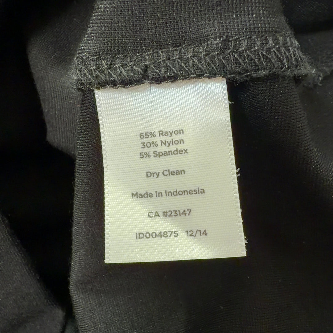 Tag view of cream and black colorblock sleeveless dress showing elegant silhouette and draping