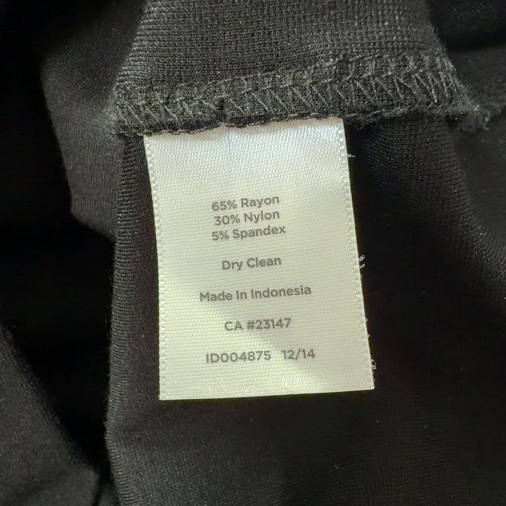 Tag view of cream and black colorblock sleeveless dress showing elegant silhouette and draping