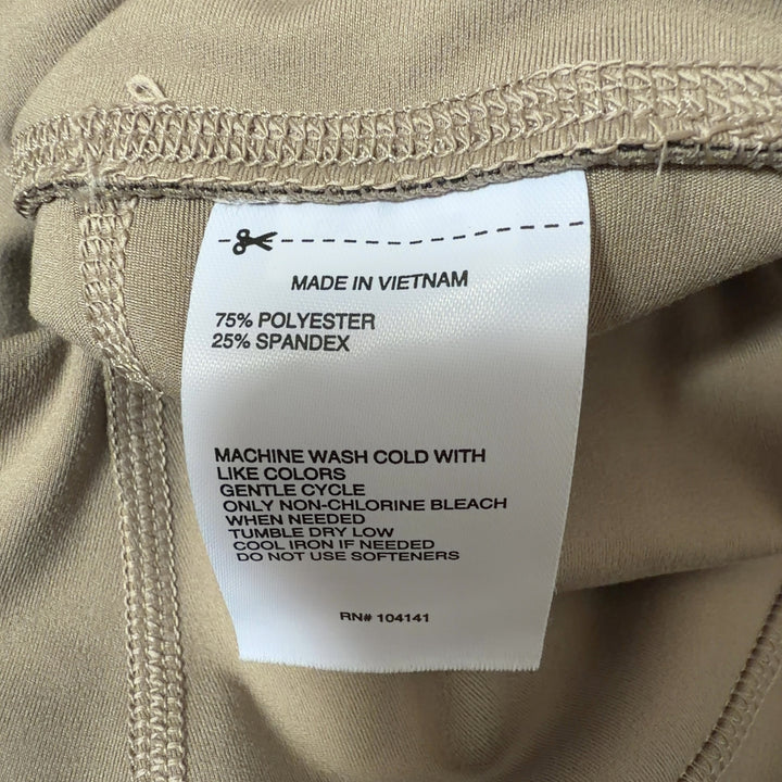 Woman wearing beige high-waist capri leggings with side pockets, back view showing fitted silhouette