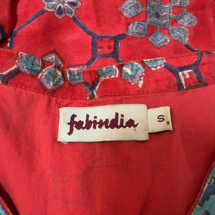 Red floral tunic top with contrasting blue trim and three-quarter bell sleeves, back view