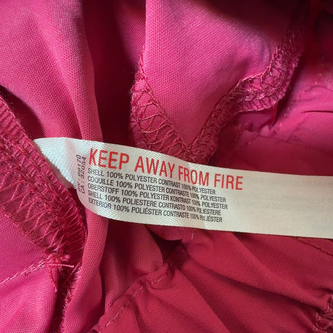 Red athletic shorts with mesh pockets, side view showing relaxed fit and length