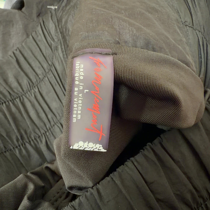Black athletic shorts with gathered elastic waistband, side view on model