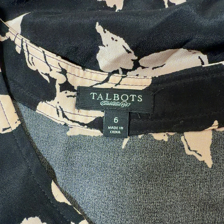 Black floral silk sleeveless top with cream and beige flower print, back view showing side profile