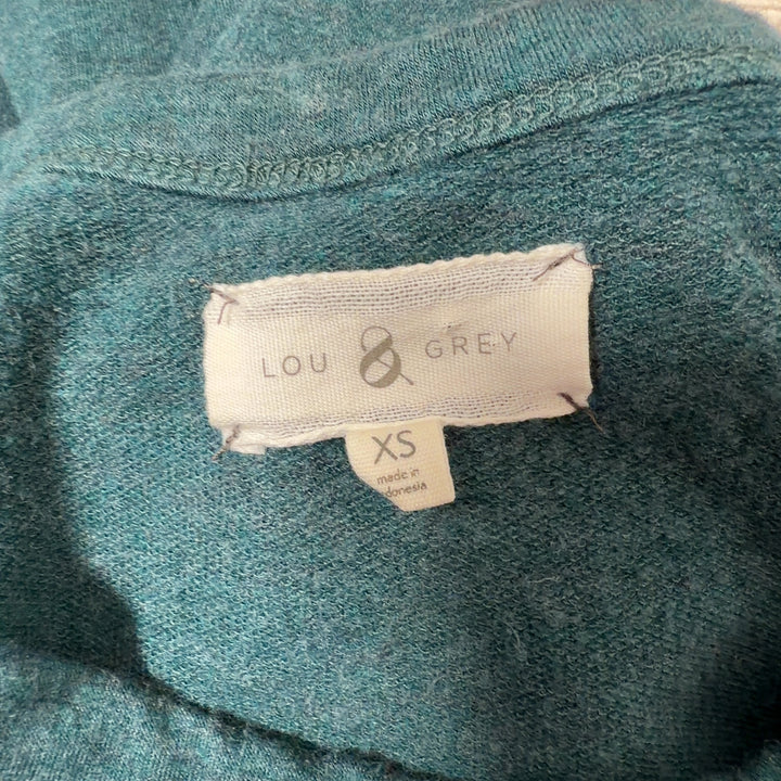 Tag view of teal rayon spandex knit dress showing relaxed silhouette and knee length hem