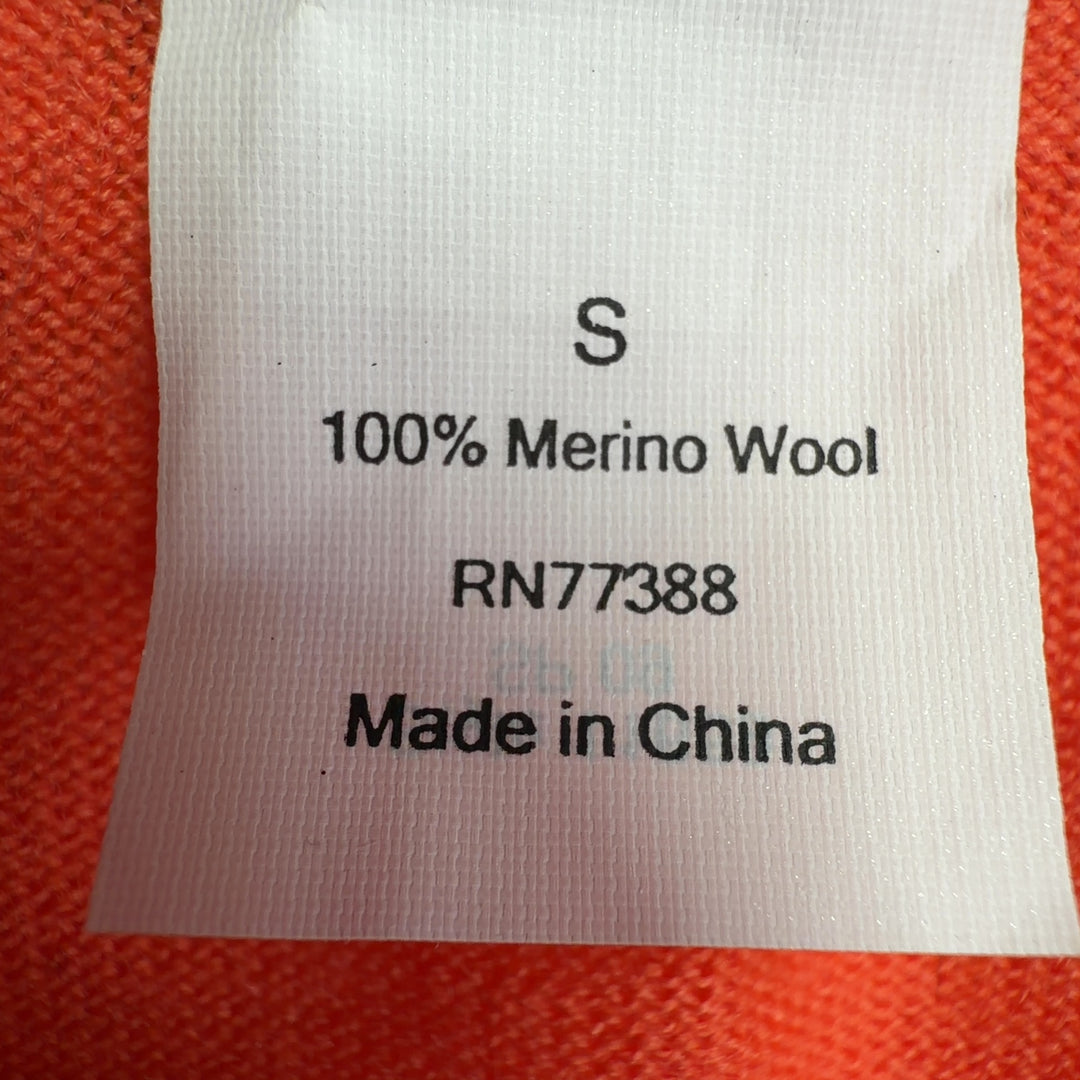 Tag view of orange merino wool cardigan showing relaxed fit and ribbed cuffs
