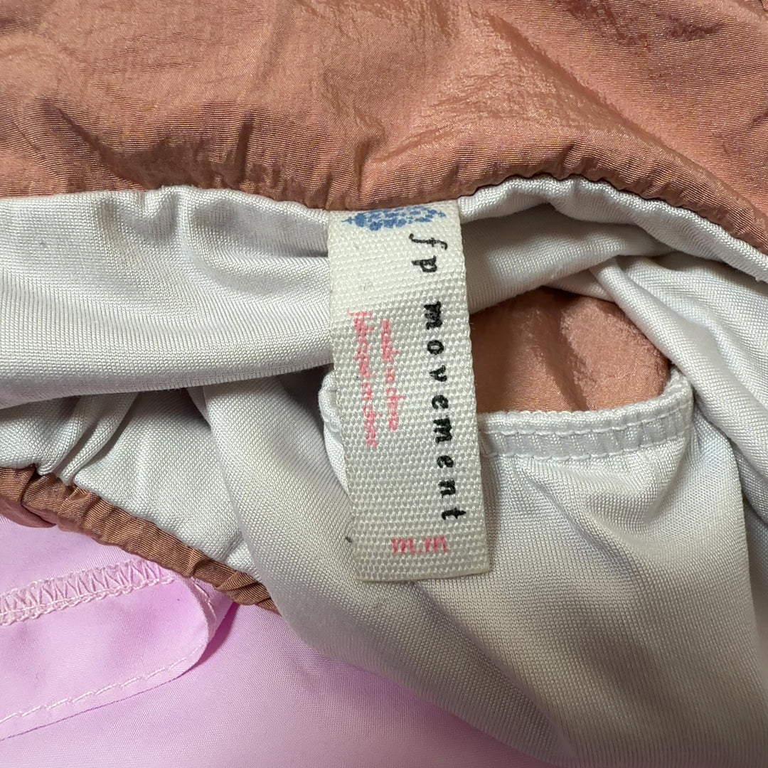 Peach high-waisted athletic shorts with relaxed fit, back view on model