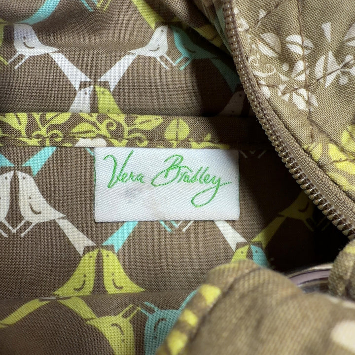 Tag view of yellow quilted Vera Bradley crossbody bag worn across body showing rear pocket detail