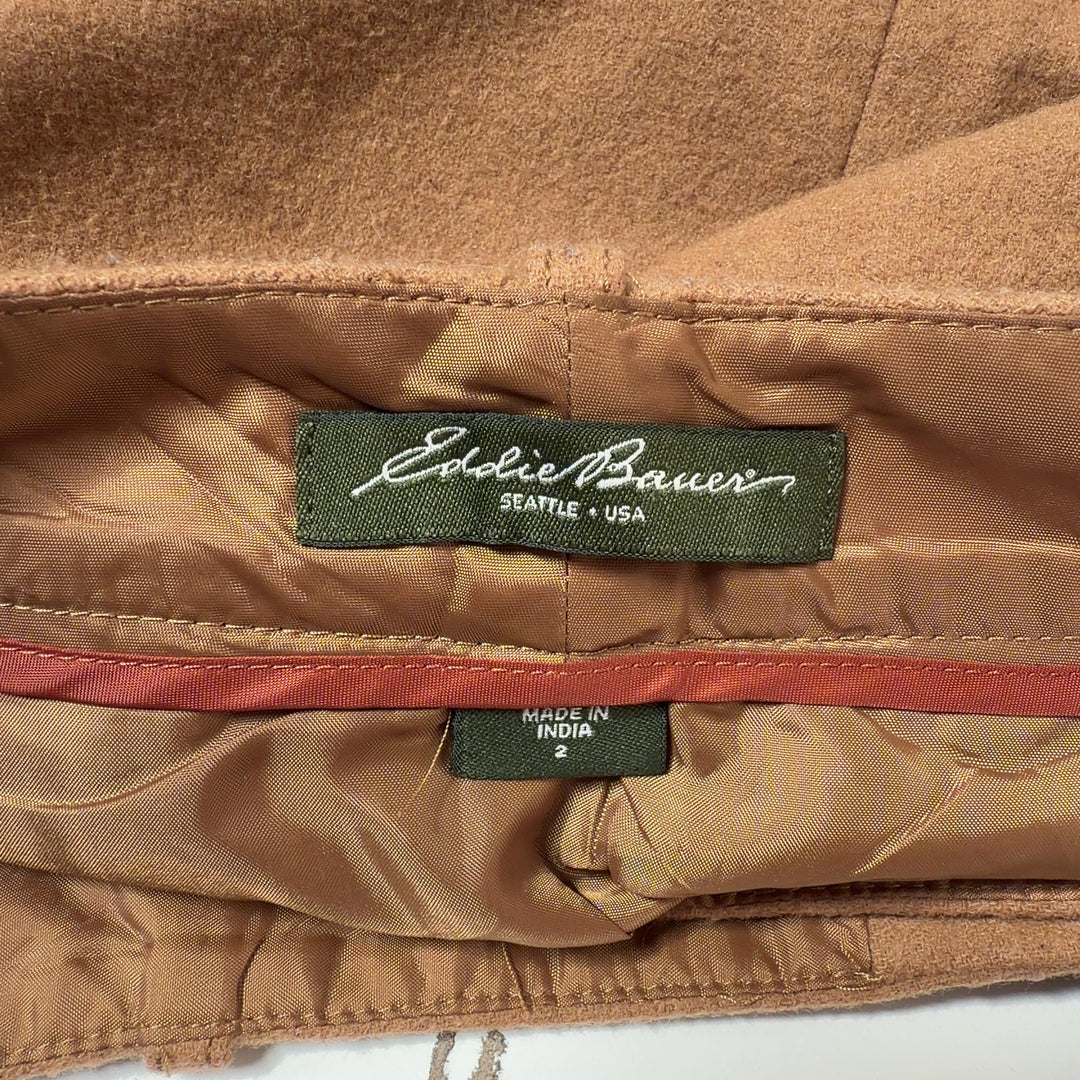 Tan button-front A-line skirt back view showing structured silhouette and button closure