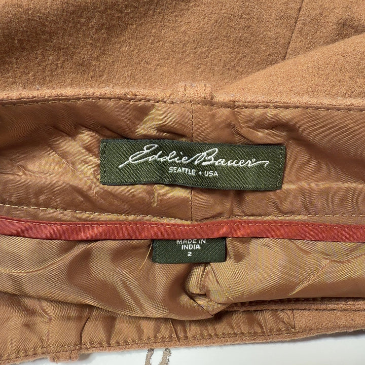Tan button-front A-line skirt back view showing structured silhouette and button closure