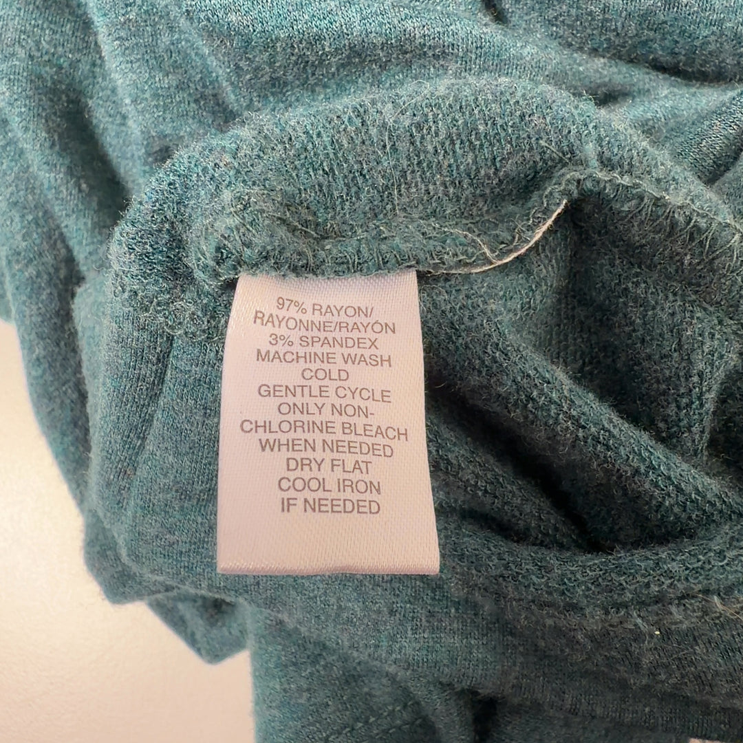 Tag view of teal rayon spandex knit dress showing relaxed silhouette and knee length hem