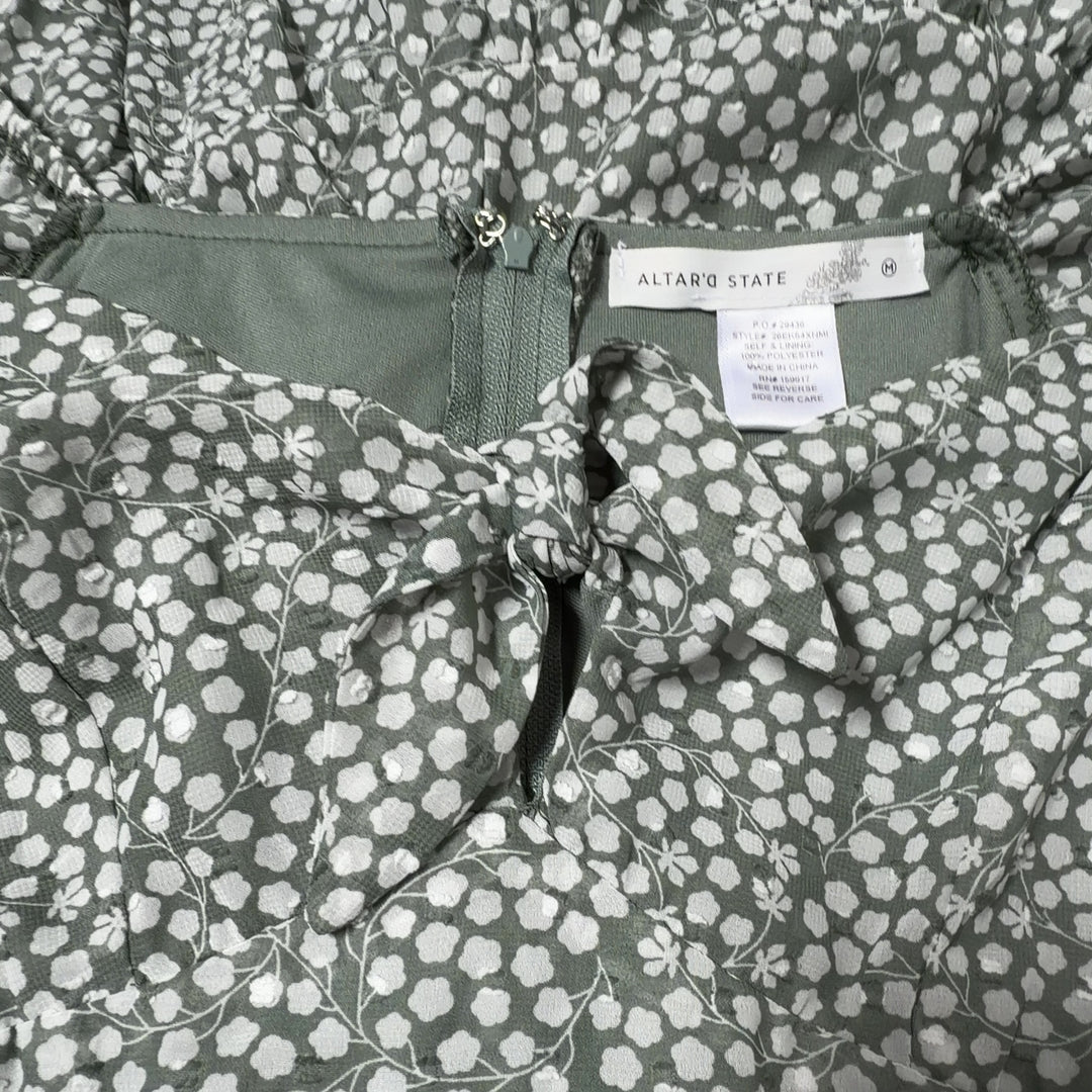 Tag view of sage green floral dress showing gathered bodice and tiered skirt design