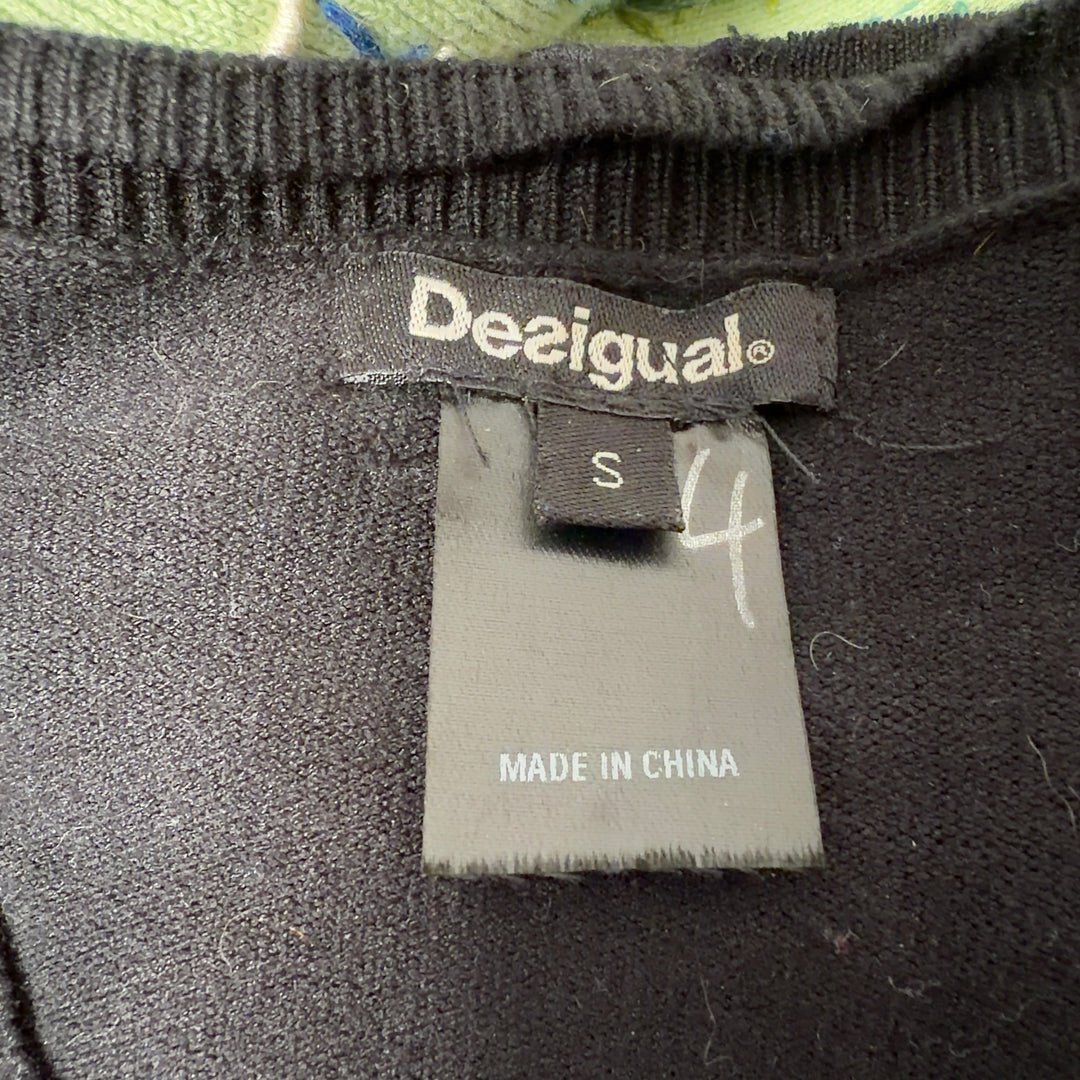 Tag view of black Desigual cardigan showing floral embroidered hem and folk-inspired geometric border pattern