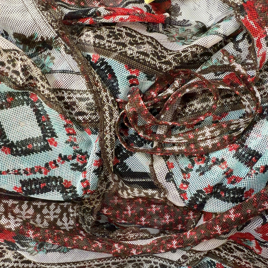Tag view of rust patchwork knit top showing mixed pattern design and long sleeve construction