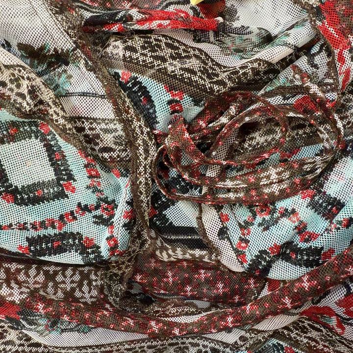 Tag view of rust patchwork knit top showing mixed pattern design and long sleeve construction