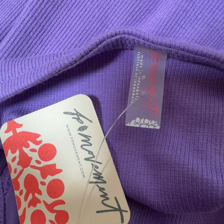 Tag view of purple sleeveless tank top showing fitted silhouette and V-neckline