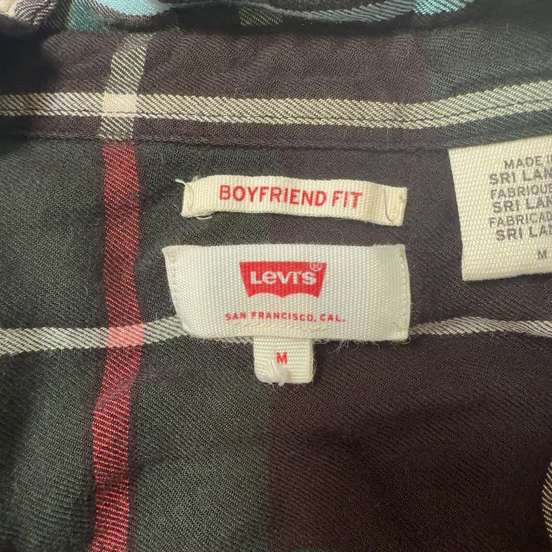 Tag view of black plaid flannel shirt showing full plaid pattern and relaxed fit silhouette