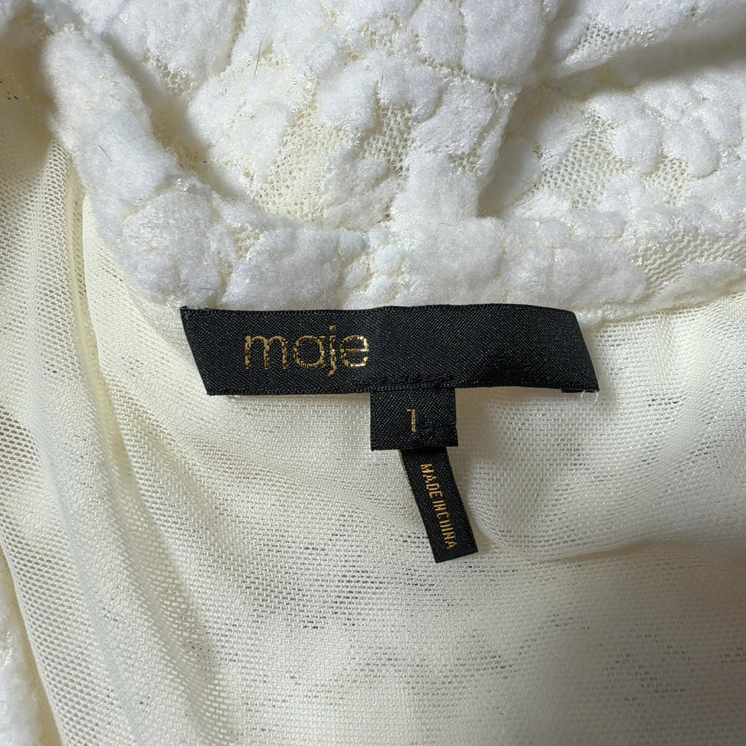 Tag view of Maje cream textured knit puff sleeve top showing fitted design and quality construction