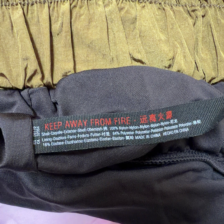 Olive nylon activewear shorts with functional side pockets and relaxed fit, side view