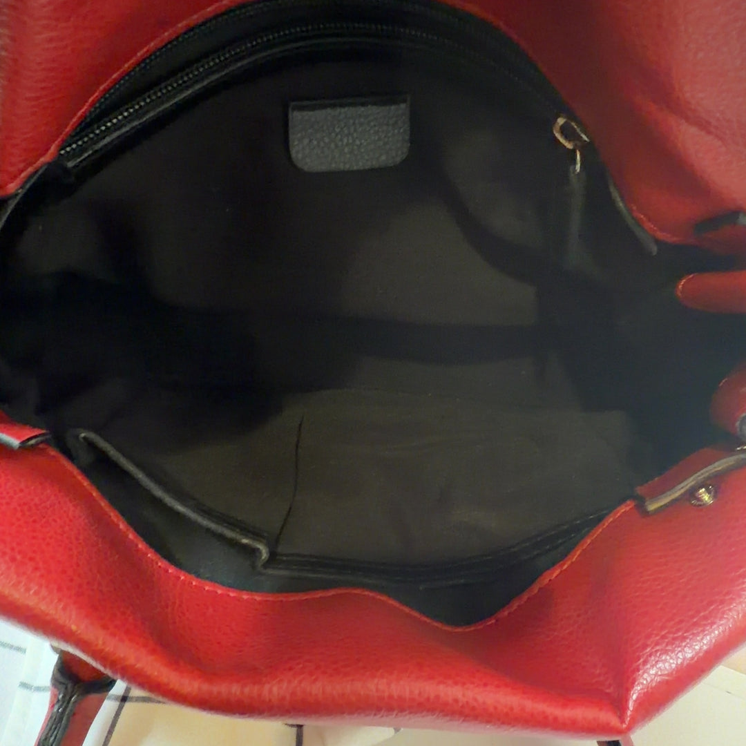 Tag view of red leather shoulder bag with dual shoulder straps worn by model