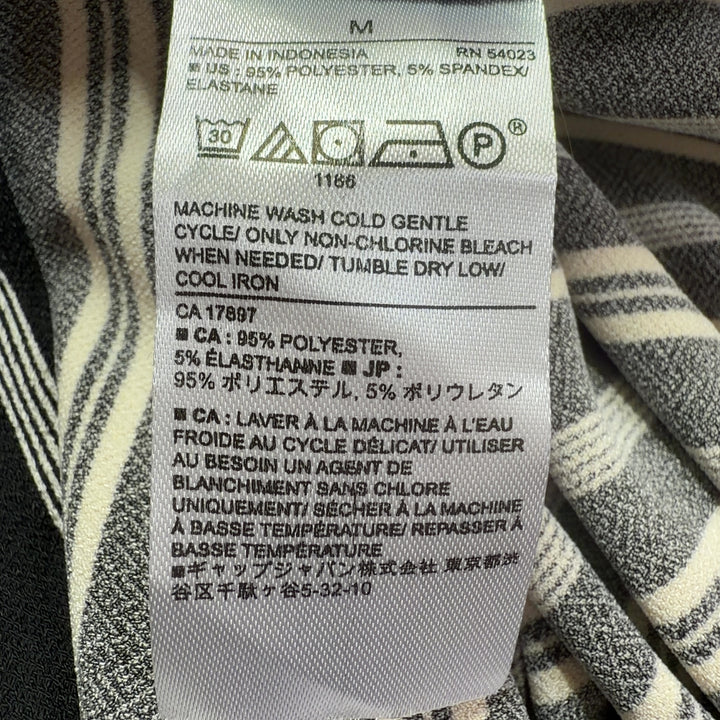 Black and white striped asymmetrical midi dress back view showing asymmetrical hemline
